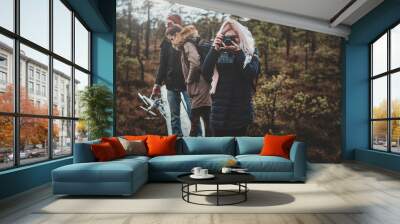 Best friends are enjoying nice hike in beautiful pine forest in autumn season. Wall mural