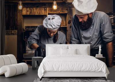 Cooking master class in bakery. Chef with his assistant showing ready samples of baking test in kitchen. Wall mural