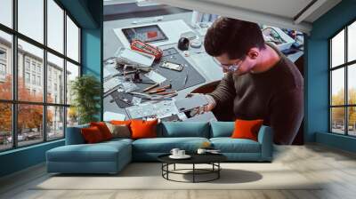 Electronic technician holds two identical smartphones for comparison, in one hand broken and in another new Wall mural