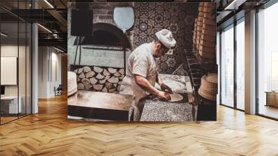 Italian chef in uniform is preparing pastry for pizza at the kitchen. Wall mural