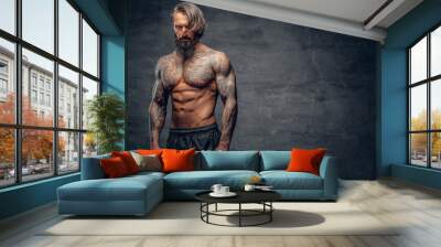 Shirtless, tattooed bearded male over dark grey vignette background. Wall mural