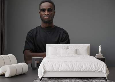 Studio shot of black man with dressed in t shirt posing with crossed arms. Wall mural