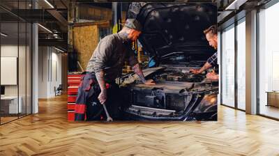 Two mechanics fixing car's engine in a garage. Wall mural