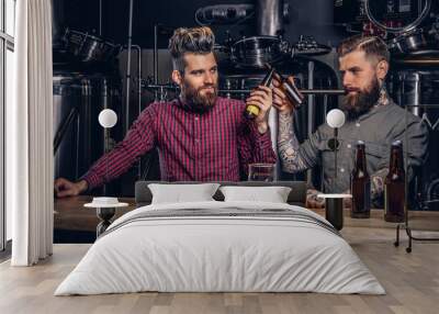 Two stylish bearded hipsters friends drinking beer together at indie brewery. Wall mural