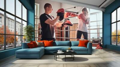 Young boxer trainer is training new girl boxer for special competitions. Wall mural