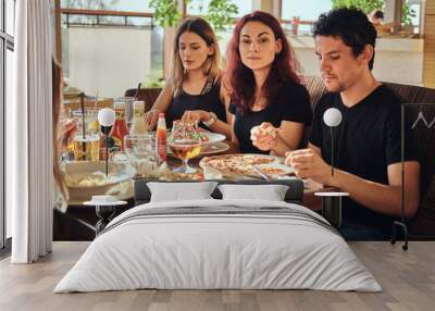 Young friends enjoying pizza and salad in a outdoor cafe Wall mural