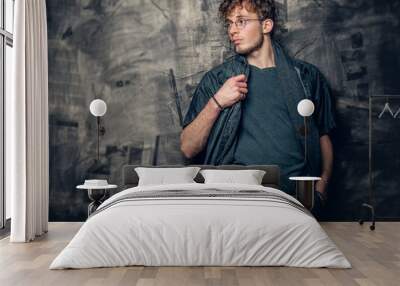 Young man in eyeglasses over grey background. Wall mural