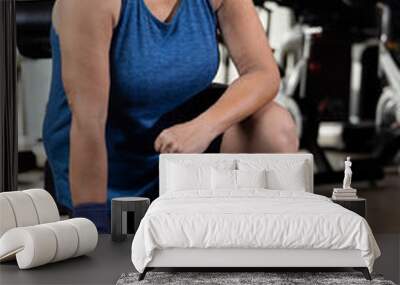 Woman kneeling on floor with dumbbell
 Wall mural