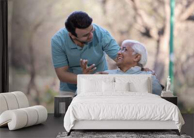 Young man having fun with his father on wheelchair at park Wall mural