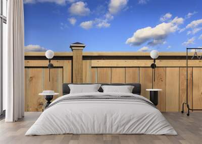 New, contemporary wood fence with blue sky and clouds in the background Wall mural