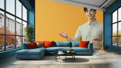 Studio portrait of A handsome  asian man with a smile on his face pointing at an empty space wearing casual clothes isolated on a colored background for advertising or just copy space Wall mural