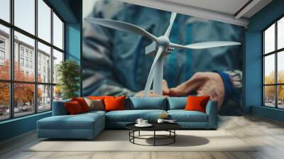 A man is holding a wind turbine in his hand Wall mural