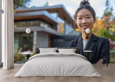 An Asian female real estate agent in a chic outfit stands proudly in front of a contemporary home with a minimalist aesthetic and a spacious driveway Wall mural