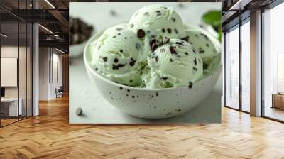 Fresh mint ice cream with chocolate chips melting, contrasting against a crisp white background Wall mural