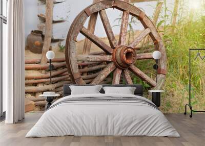 Old wooden wheel in nature background. Country life. Retro wooden wheel. Wall mural