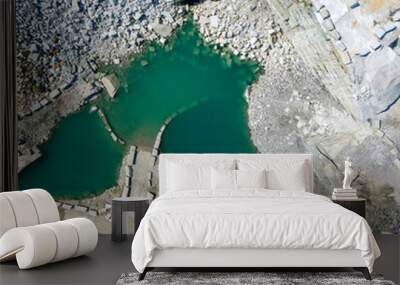 Aerial bird's eye view of white marble stone quarry with vibrant blue pons of water and sharp cut rocks Wall mural