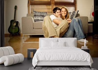 Happy young couple having fun on the sofa Wall mural