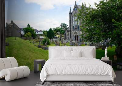 St Canice's Cathedral cemetery with green grass and old gravestones. Essential part of the heritage in the vibrant medieval city of Kilkenny in Ireland. Wall mural