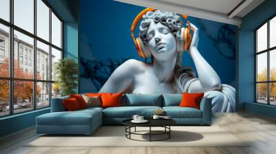 white marble bust on pedestal of a woman aphrodite with eyes closed, feeling the music with orange headphones, blue plain background Wall mural