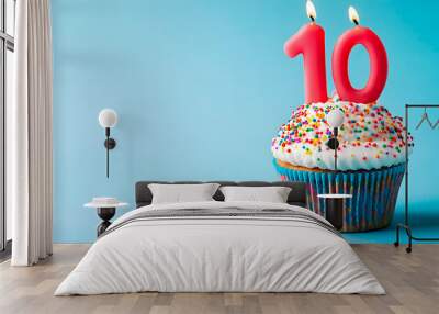 Cupcake with cream and colored sprinkles, to celebrate an anniversary or 10th birthday, red candles Wall mural