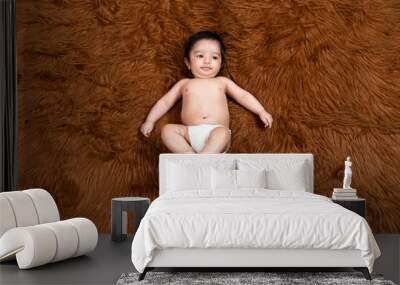 Cute little indian baby wearing diaper lying on brown fur background. Asian two months old newborn baby. Wall mural