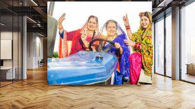 Group of happy punjab women driving tractor at agriculture field outdoor. Rural india. Wall mural