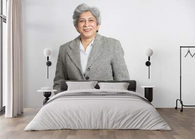 Happy confident mature senior indian business woman in a suit standing isolated on white background. smiling successful asian 60s gray-haired lady executive or business leader. Wall mural