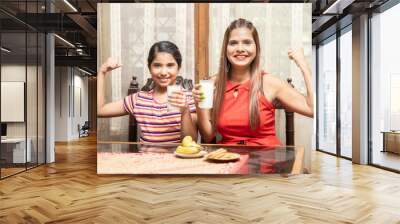 Indian mother and daughter drink milk together to get calcium. having breakfast in kitchen, happy family, healthy diet and strong concept. Wall mural