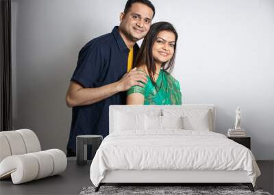 Portrait of happy young indian couple isolated on white background. Asian female wearing saree and male wearing casual shirt, husband and wife. Wall mural