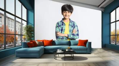 portrait of smiling cute little indian boy standing with cross arms isolated on white studio backgro Wall mural