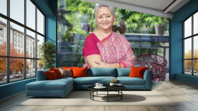 Portrait of smiling senior indian woman wearing sari standing with cross arms looking at camera. Wall mural