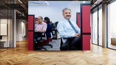 senior indian professional man working in corporate office and looking at camera. business and workspace concept. Wall mural