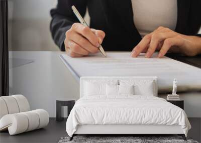 Businesswoman signing a document or application form in a folder Wall mural