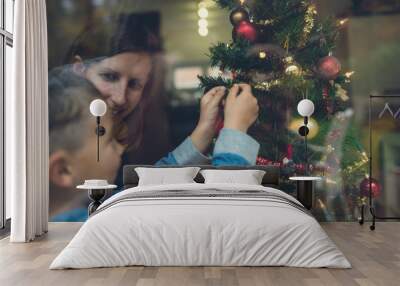 Mother and son decorating Christmas tree Wall mural