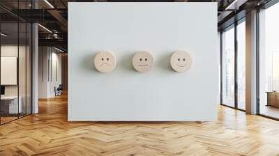 Wooden cut circles with faces representing positive, negative and neutral grade Wall mural