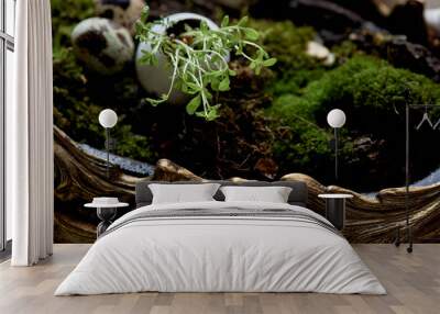 A massive bronze vase on legs with moss, greenery sprouted in an egg. A new life Wall mural