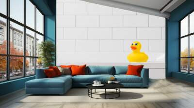 Toy yellow duck in the bathroom on a light brick background Wall mural