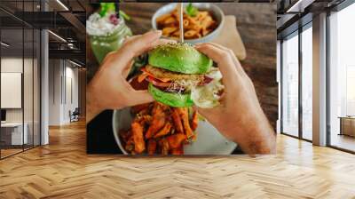 vegetarian green burger in the hands of a man. Healthy food. Modern useful fast food. Wall mural