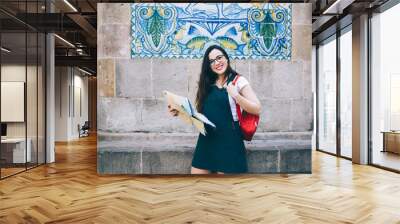 Cheerful caucasian woman in eyewear looking at camera enjoying free time on traveling hobby on vacations, half length portrait of smiling 20 female tourist using map searching historical places Wall mural