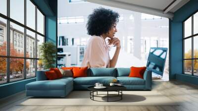 Woman watching webinar on laptop in library Wall mural