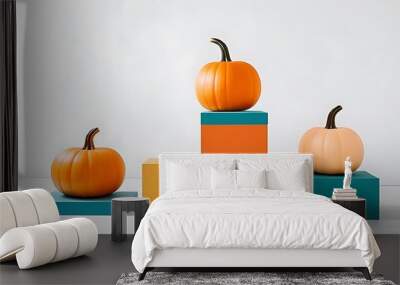 Colorful pumpkins displayed on vibrant podiums and pedestals against a white background, embodying a festive Halloween concept. Wall mural