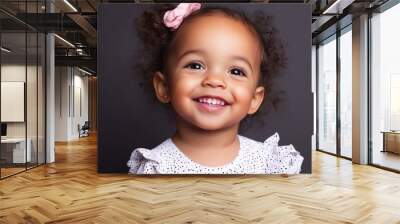 A baby with brown hair and blue eyes laughs. Wall mural