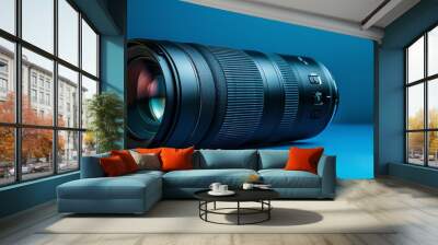 A black camera lens on a blue surface. Wall mural