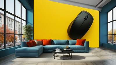 A black computer mouse on a yellow background. Wall mural