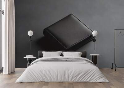 A black leather wallet on a dark grey surface. Wall mural