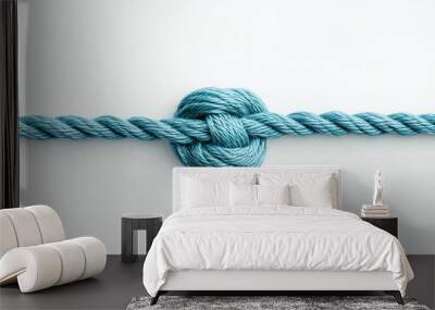 A blue rope tied into a knot on a white background. Wall mural