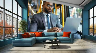 A businessman in a suit is on a bus using his laptop. Wall mural