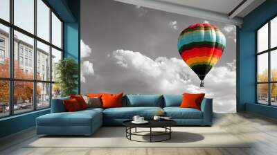 A colorful hot air balloon floats in a black and white sky. Wall mural