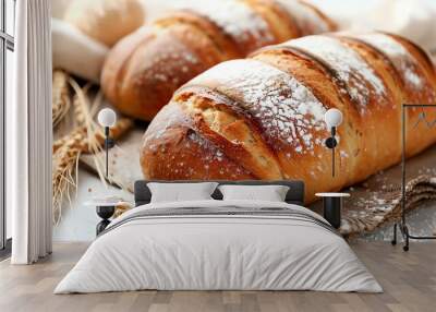 A loaf of freshly baked bread with wheat stalks and flour scattered around it. Wall mural