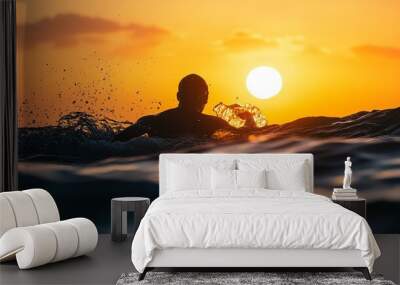 A man swims in the ocean at sunset. Wall mural